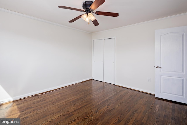 unfurnished bedroom with baseboards, ceiling fan, ornamental molding, dark wood-type flooring, and a closet