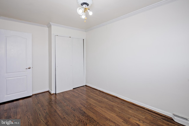 unfurnished bedroom featuring baseboards, dark wood-style flooring, crown molding, a baseboard heating unit, and a closet