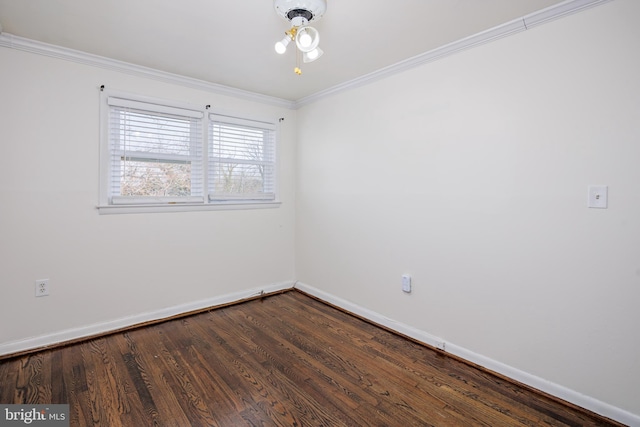 spare room featuring baseboards, dark wood finished floors, and crown molding