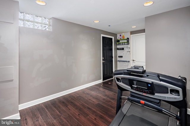 exercise room with recessed lighting, wood finished floors, and baseboards