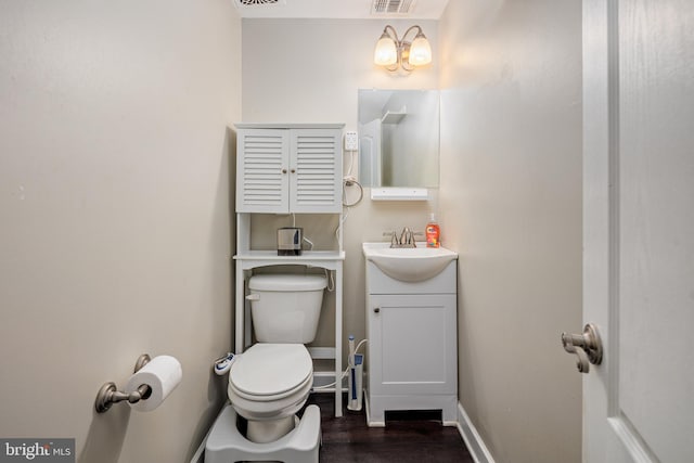 bathroom featuring baseboards, visible vents, vanity, and toilet