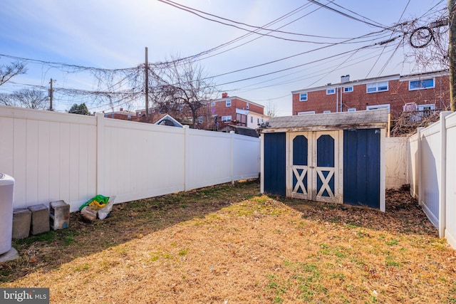 view of yard with a shed, an outdoor structure, and a fenced backyard