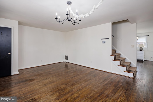 interior space featuring visible vents, baseboards, wood-type flooring, an inviting chandelier, and stairs