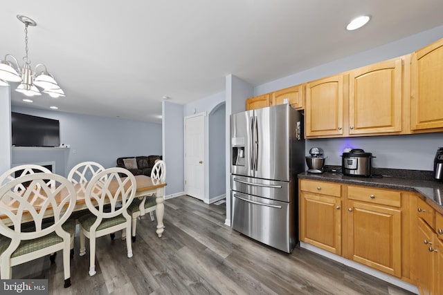 kitchen with arched walkways, dark wood-style flooring, stainless steel refrigerator with ice dispenser, and an inviting chandelier