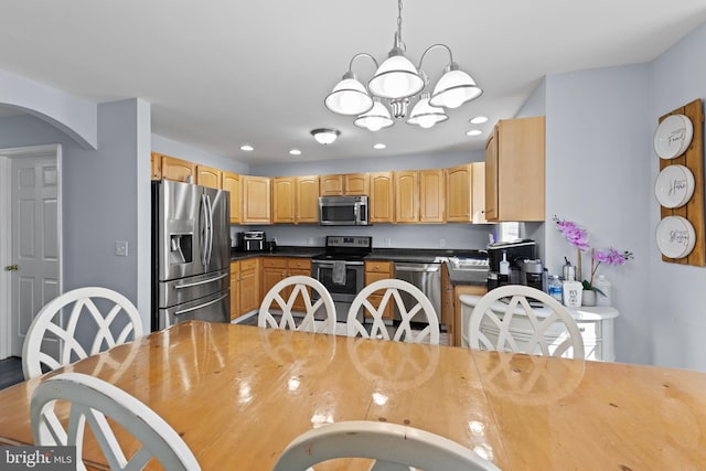 kitchen featuring stainless steel appliances, recessed lighting, a chandelier, and dark countertops