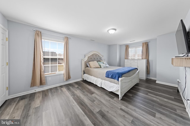 bedroom with multiple windows, baseboards, and wood finished floors