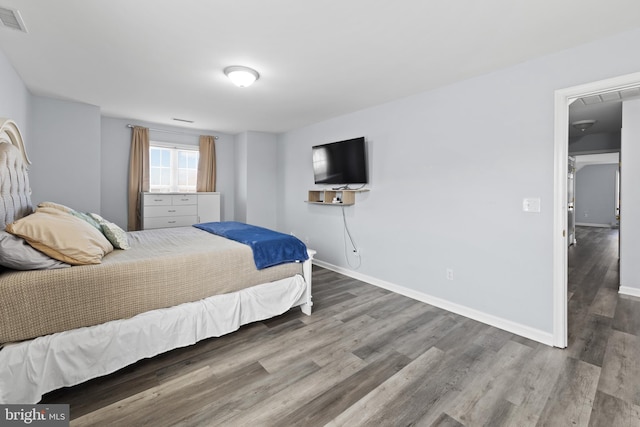 bedroom featuring visible vents, baseboards, and wood finished floors