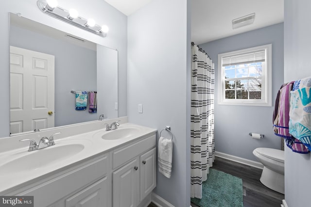 full bath featuring visible vents, a sink, toilet, and double vanity