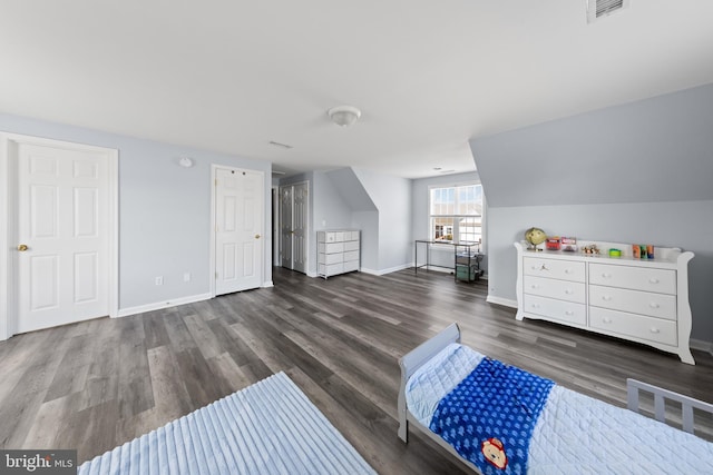 bedroom with visible vents, vaulted ceiling, baseboards, and wood finished floors