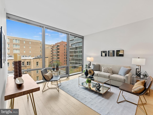 living area with a wall of windows and wood finished floors