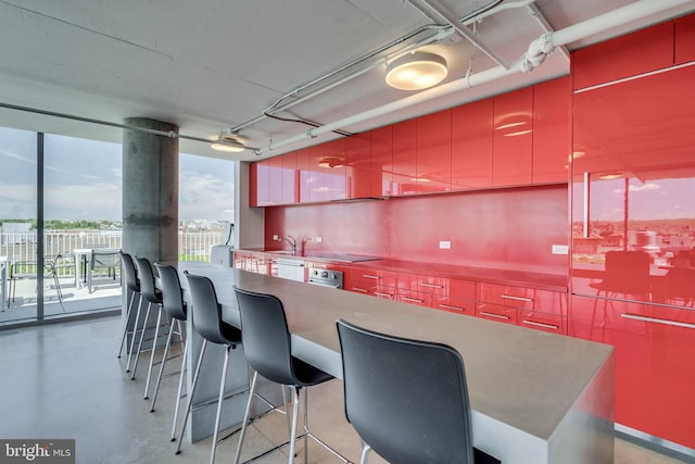 kitchen featuring concrete floors, a breakfast bar area, and modern cabinets