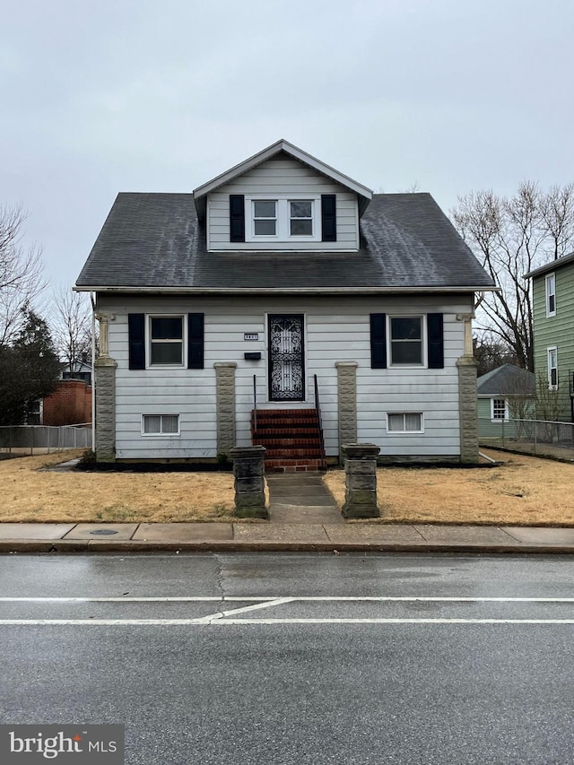 bungalow-style home with fence