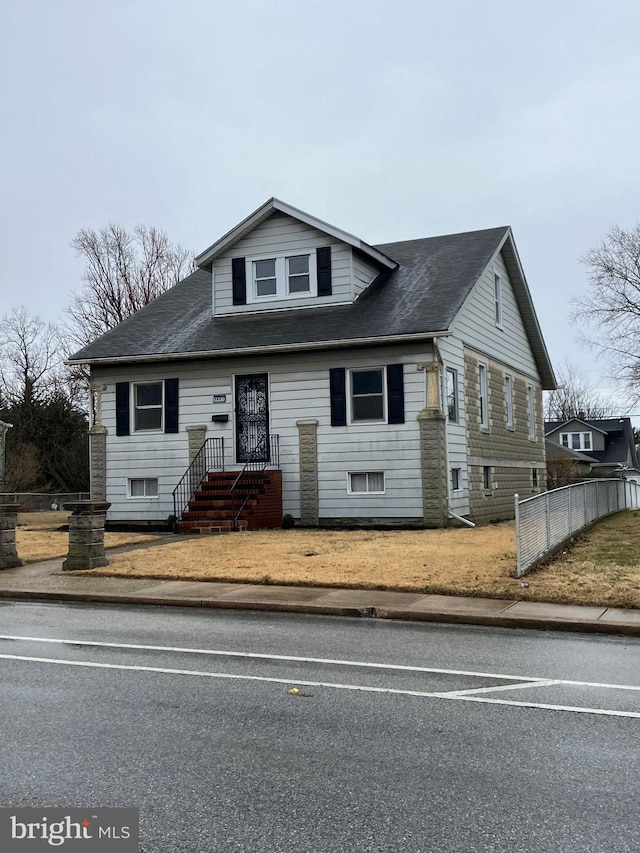 bungalow-style house with fence