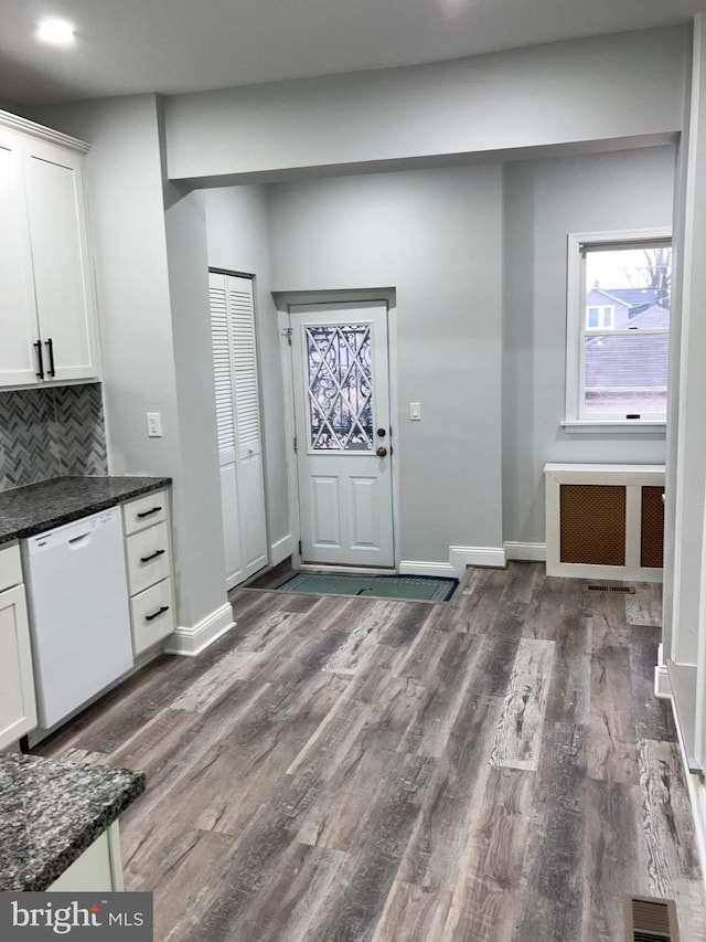 kitchen with dishwasher, dark wood-style flooring, white cabinetry, and radiator