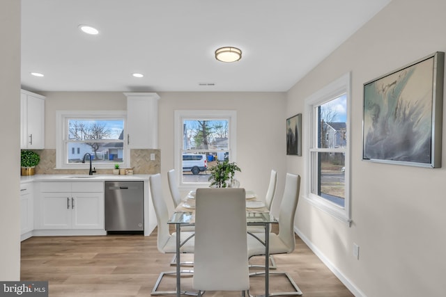 dining area featuring plenty of natural light, light wood-style flooring, and baseboards