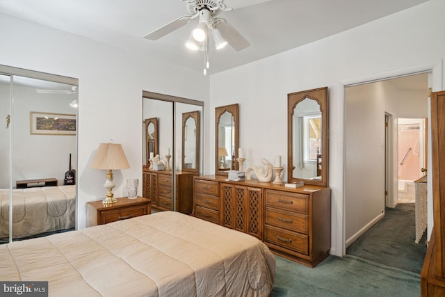 bedroom with dark carpet, two closets, and a ceiling fan