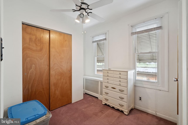 carpeted bedroom with a closet, a ceiling fan, and radiator