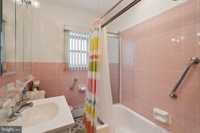 bathroom with baseboard heating, shower / bath combo with shower curtain, tile walls, and vanity