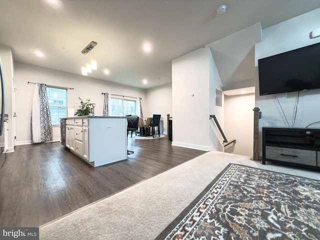 kitchen featuring dark wood-style flooring, a kitchen island, visible vents, white cabinets, and pendant lighting