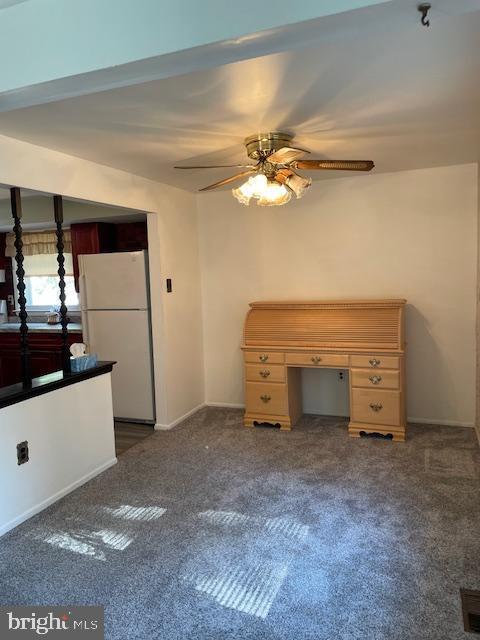 interior space with freestanding refrigerator, ceiling fan, and carpet