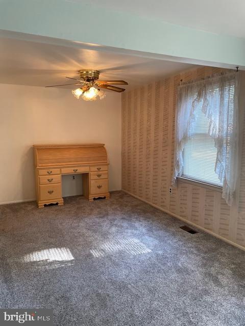 unfurnished bedroom with carpet floors, visible vents, and a ceiling fan