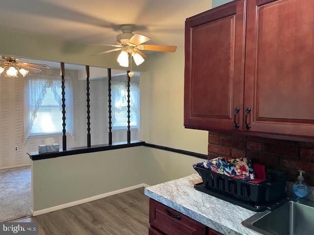 kitchen with ceiling fan, light countertops, dark wood finished floors, and a healthy amount of sunlight