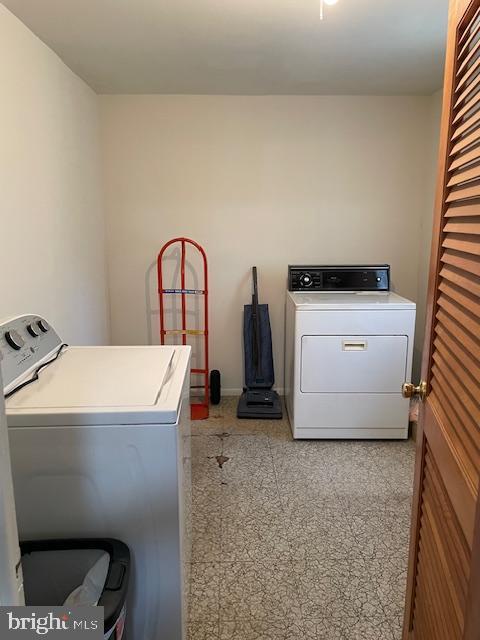 laundry area featuring laundry area, baseboards, and washer and clothes dryer