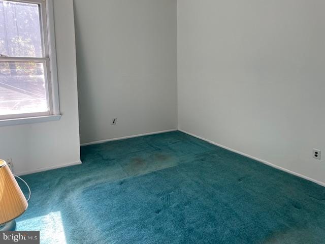 unfurnished room with carpet and baseboards