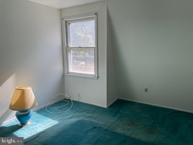 carpeted spare room with baseboards