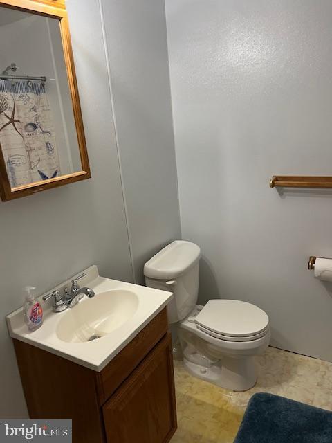 full bath featuring vanity and toilet