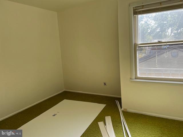 unfurnished room with baseboards