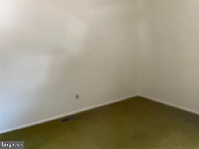 unfurnished room with baseboards