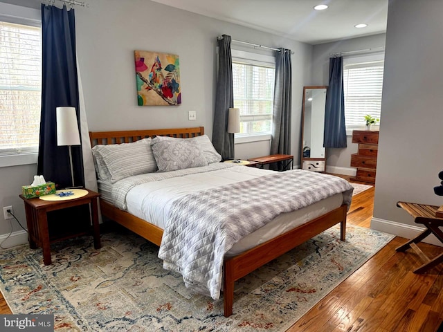 bedroom with recessed lighting, multiple windows, baseboards, and hardwood / wood-style flooring