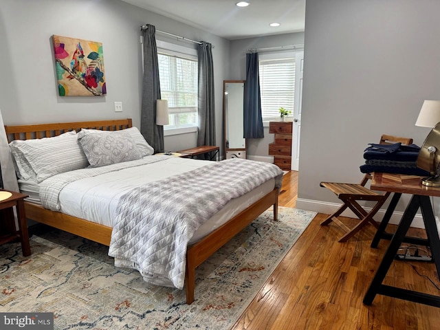 bedroom with baseboards, hardwood / wood-style floors, and recessed lighting