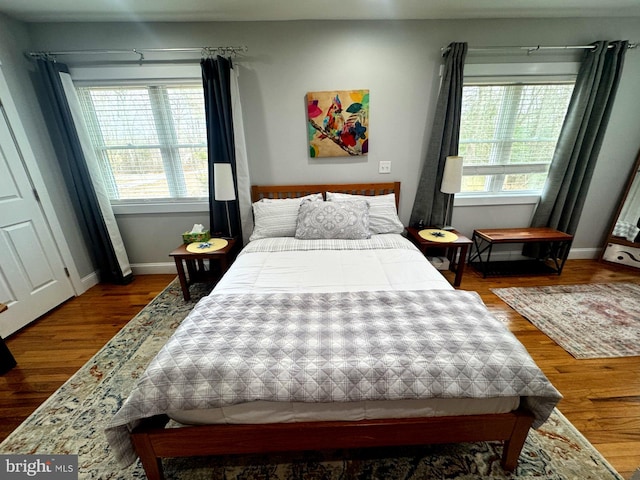 bedroom with baseboards and wood finished floors