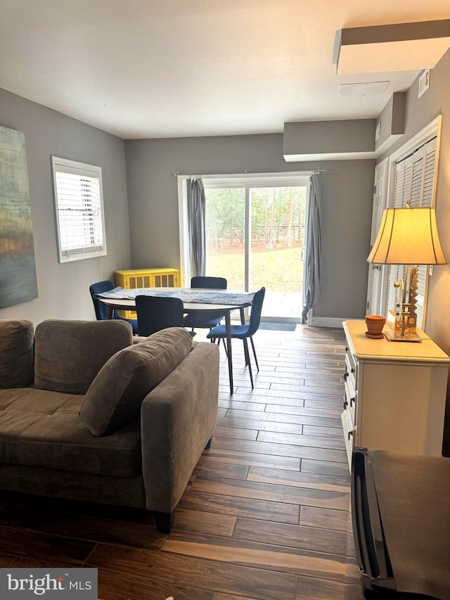 living area with dark wood-style floors and visible vents