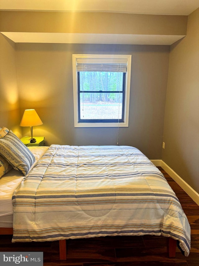 bedroom featuring baseboards and wood finished floors