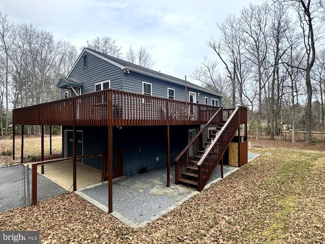 rear view of property with stairs, fence, a deck, and a patio