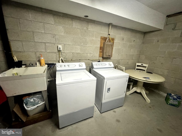 laundry area with concrete block wall, laundry area, a sink, and independent washer and dryer