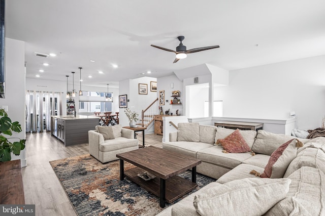 living area featuring visible vents, a ceiling fan, stairway, light wood-type flooring, and recessed lighting