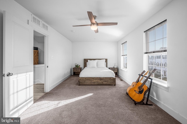 carpeted bedroom with ceiling fan, visible vents, and baseboards