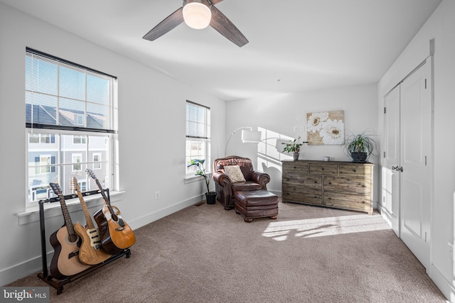 living area with carpet floors, ceiling fan, and baseboards