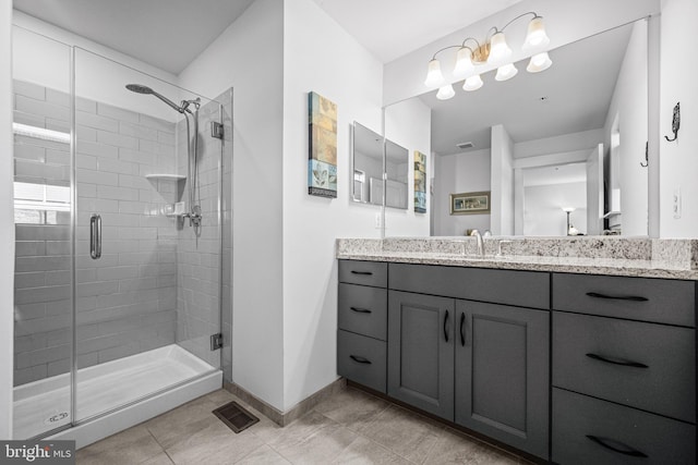 bathroom with a stall shower, visible vents, baseboards, tile patterned flooring, and vanity