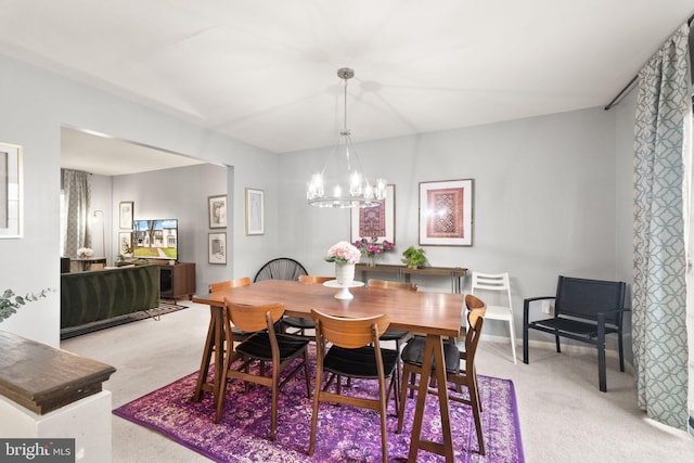 dining area with light carpet, baseboards, and a chandelier