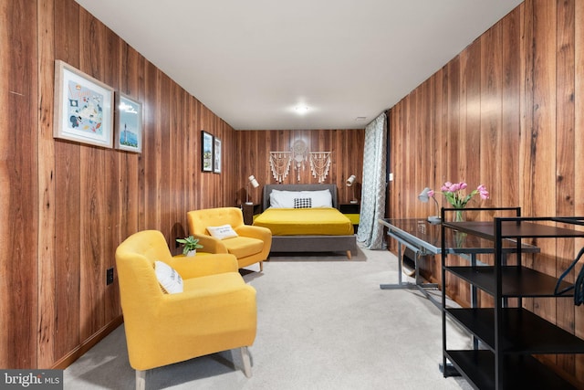 sitting room with carpet and wooden walls