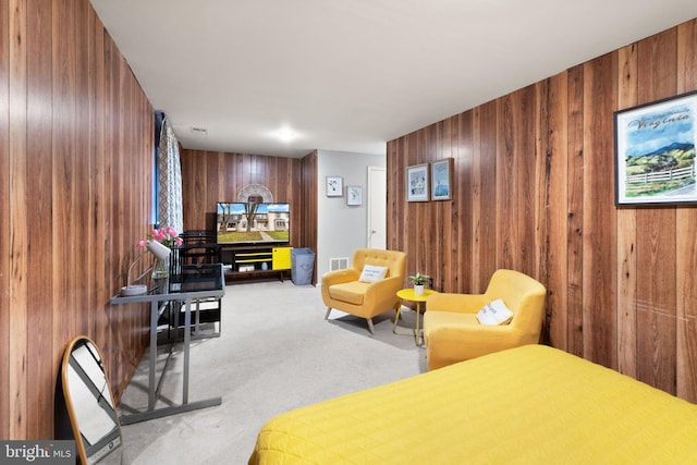 carpeted bedroom featuring wood walls and visible vents