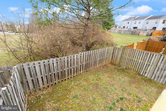 view of yard featuring a fenced backyard and a residential view