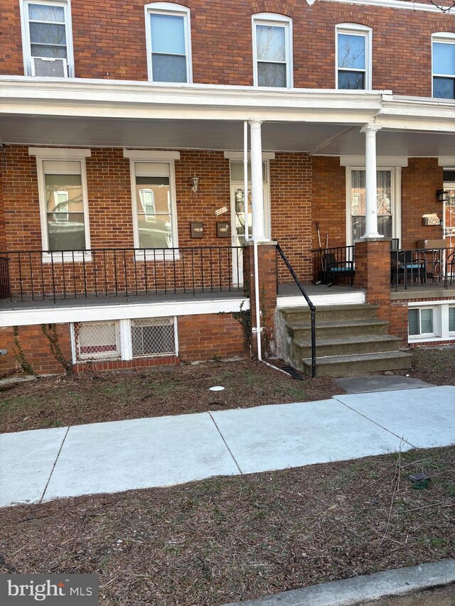 611 E 37th St, Baltimore, MD 21218 - entrance to property featuring a porch and brick siding
