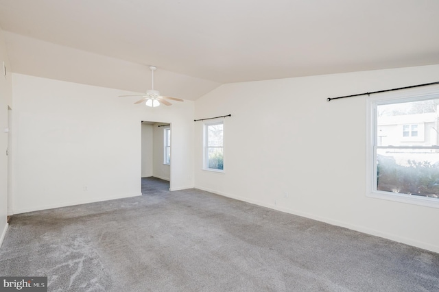 spare room featuring lofted ceiling, carpet flooring, a ceiling fan, and baseboards