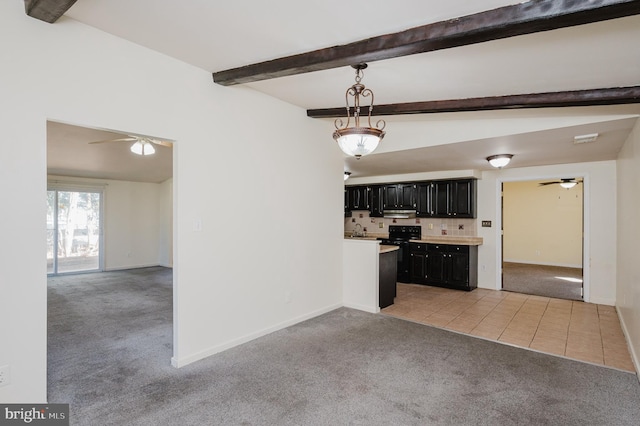 kitchen with dark cabinetry, beam ceiling, light tile patterned flooring, ceiling fan, and light carpet